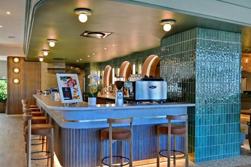 a bar in a restaurant with a blue counter and stools at City Lodge Hotel Umhlanga Ridge in Durban