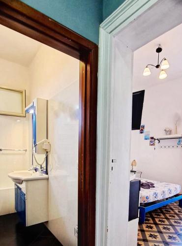 a bathroom with a sink and a bed in a room at Stella del Sud in Catania