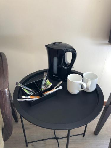 Una mesa negra con dos tazas de café encima. en Jølster Lake View, en Årdal