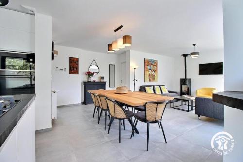 une cuisine et une salle à manger avec une table et des chaises en bois dans l'établissement La maison de kervozes, à Quiberon