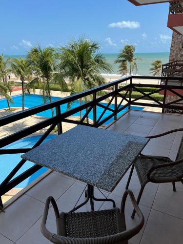 a table and chairs on a balcony with the beach at Kariri Beach Residence in Caucaia
