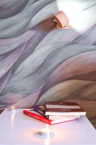 a pile of books sitting on a table in front of a mural at A Casa di Lu' Elegant Rooms in Monterotondo