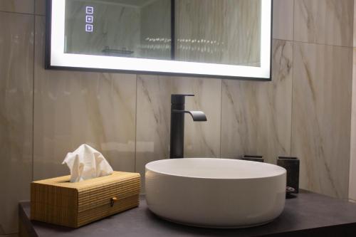 a bathroom with a large white sink and a basket at Annis House in Epanomi