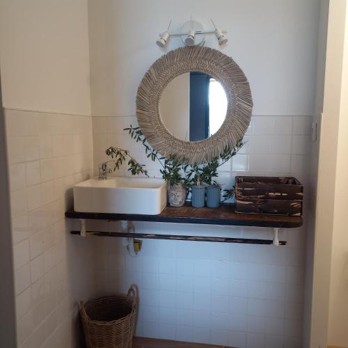 a bathroom with a sink and a mirror on a shelf at Casas Coração in Codeçoso