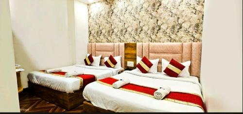 アムリトサルにあるHOTEL Sunny Innのベッド2台(赤と白の枕付)が備わる客室です。