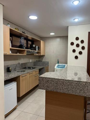 a kitchen with granite counter tops and a kitchen with a sink at Kariri Beach Residence in Caucaia