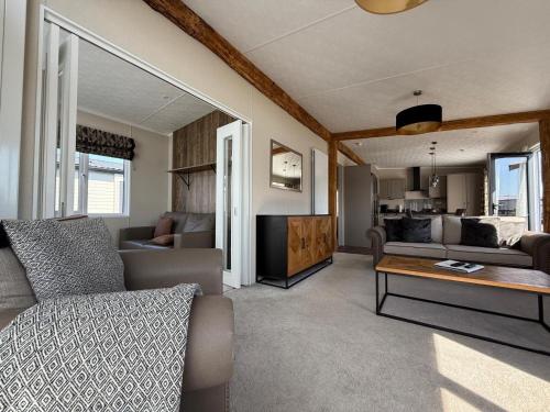 a living room with a couch and a table at Luxury Lodge Retreat with Hot Tub - Stewarts Resort 19 in St. Andrews