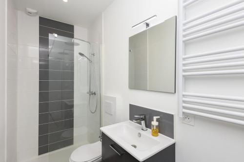 une salle de bain blanche avec un lavabo et une douche dans l'établissement Cervoise, à Brest