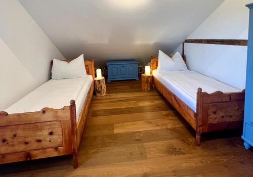 two twin beds in a attic room with lights at Wohnen am Penzkofergut in Feichten