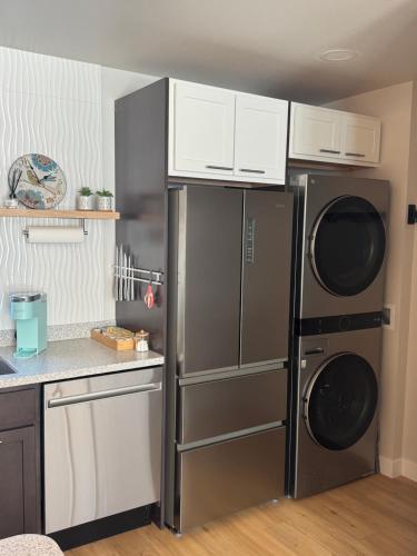 a kitchen with a stainless steel refrigerator and cabinets at DWELL in Alaska Apartment h in Fairbanks