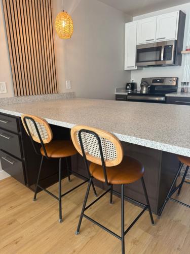 a kitchen with two chairs sitting at a counter at DWELL in Alaska Apartment h in Fairbanks