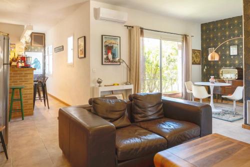 un salon avec un canapé en cuir et une table dans l'établissement Bright, vintage-style apartment, à Marseille