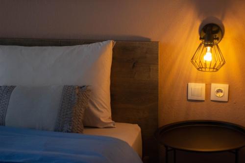 a bedroom with a bed and a light on the wall at Anni's Home in Epanomi