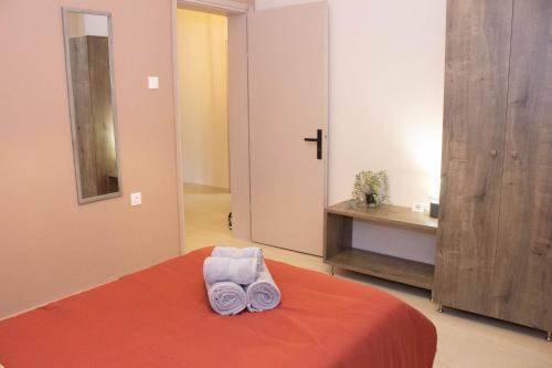 a bedroom with a bed with two towels on it at Anni's Home in Epanomi
