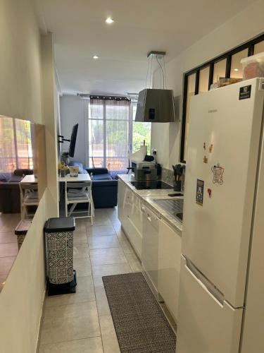 une cuisine avec un réfrigérateur blanc et une table dans l'établissement New central nice sea down town, à Nice