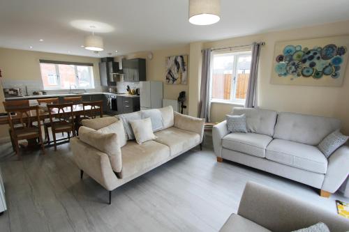 a living room with two couches and a kitchen at Newark area - modern 3 bedroom semi with free off road parking for 2 vehicles in Balderton