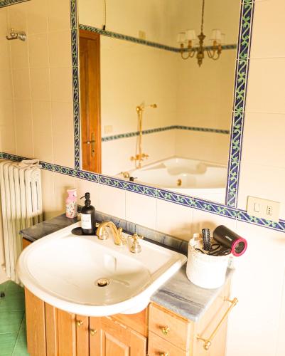 a bathroom sink with a mirror and a tub at Dimora Gentile BnB in Castiglione del Lago