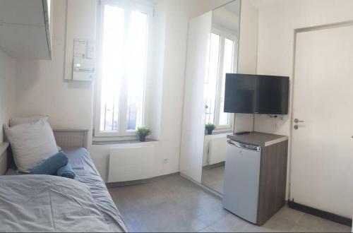 une chambre avec un lit et une télévision dans une pièce dans l'établissement Small Cocoon Marseillais, à Marseille