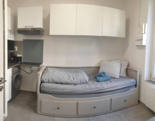 Ce petit lit se trouve dans une petite chambre dotée d'une cuisine. dans l'établissement Small Cocoon Marseillais, à Marseille