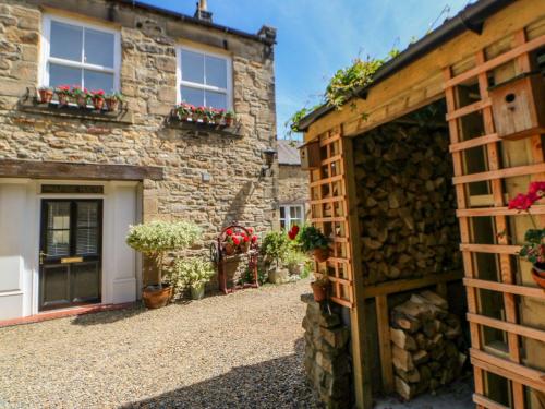 a stone house with a courtyard and a garage at Shaftoe Mews in Hexham