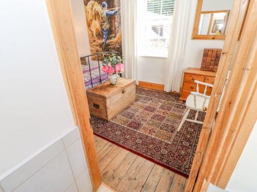 a hallway with a wooden floor and a room with a table at Shaftoe Mews in Hexham