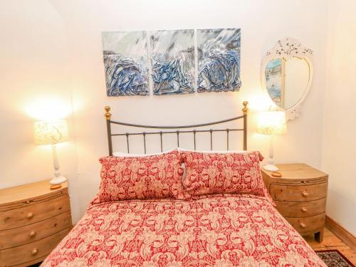 a bedroom with a bed and two lamps and a mirror at Shaftoe Mews in Hexham