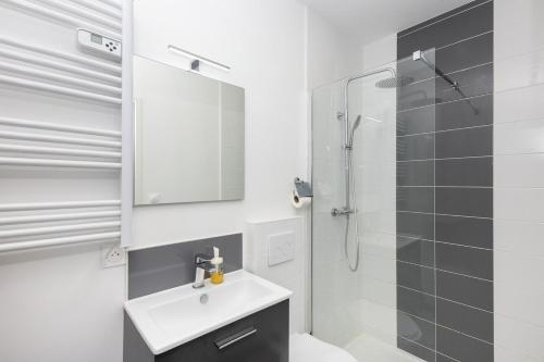 une salle de bain blanche avec un lavabo et une douche dans l'établissement Chouchen, à Brest