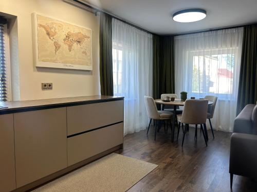 a dining room with a table with chairs and a map on the wall at Cozy STAY in City Center in Telšiai