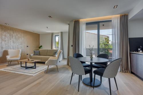 a living room with a couch and a table and chairs at Level 5 Rovinj - Adults Only in Rovinj