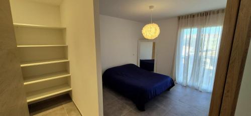 une chambre avec un pouf bleu et des étagères dans l'établissement Maison neuve 2024 avec jardin, à Prunelli-di-Fiumorbo