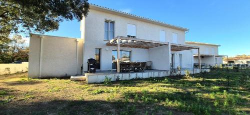 une maison avec une table et des chaises devant dans l'établissement Maison neuve 2024 avec jardin, à Prunelli-di-Fiumorbo