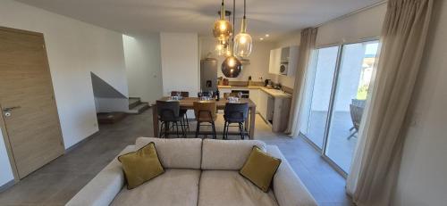 un salon avec un canapé et une table avec des chaises dans l'établissement Maison neuve 2024 avec jardin, à Prunelli-di-Fiumorbo