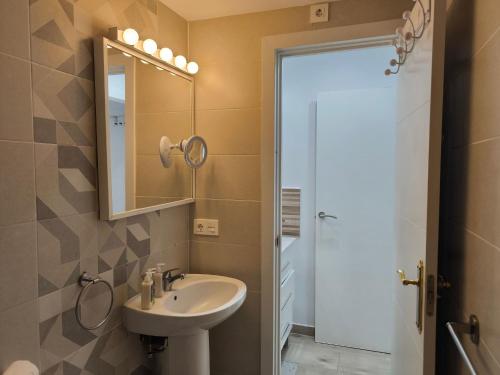 a bathroom with a sink and a mirror at Cozy Bungalow with Private Terrace and Communal Pool in Torrevieja in Torrevieja