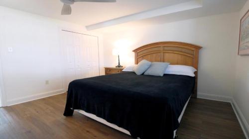 una camera da letto con un letto grande con testiera in legno di Broadway Beach Unit 1 a Cape May