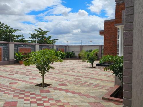 a courtyard with trees and plants in a building at King Cave Luxury Apartment in Nkunjila
