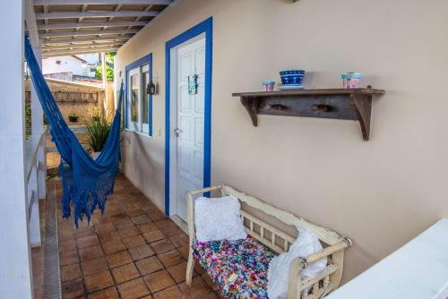 a porch with a swing and a blue door at Pousada Via Brasil in Morro de São Paulo