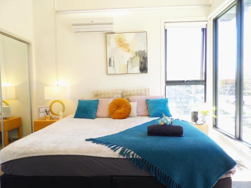 a bedroom with a large bed with blue pillows at 89B - Your Dream Stay Business or Travel Mornings with coffee in Bentleigh in Heatherton
