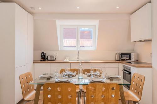 une cuisine avec une table en verre et des chaises dans l'établissement Appartement 3 chambres en centre ville et proche métro, à Croix