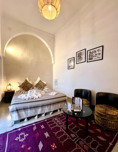 a bedroom with a bed and a table and chairs at Riad Jnan El Cadi in Marrakech