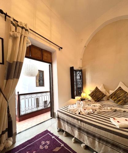 a bedroom with a bed and a window at Riad Jnan El Cadi in Marrakech