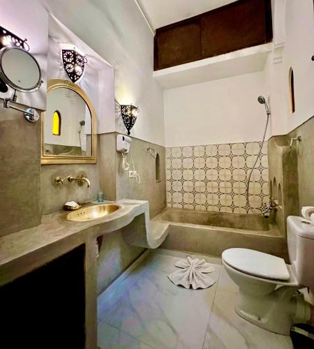 a bathroom with a sink and a toilet and a tub at Riad Jnan El Cadi in Marrakech