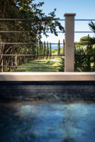a view of a yard with a fence and trees at Boutique Hotel Poggio ai Santi - Adults Only in San Vincenzo