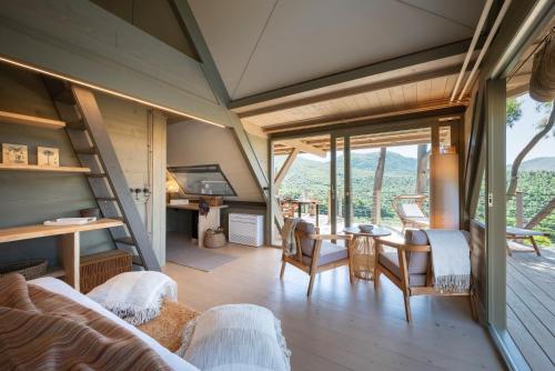 a living room with a table and chairs and windows at Boutique Hotel Poggio ai Santi - Adults Only in San Vincenzo