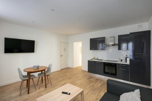 un salon avec une table et une cuisine dans l'établissement T2 Cotriade, à Brest