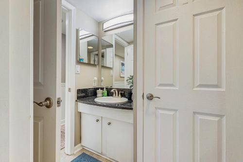 un baño con lavabo y espejo en Golden Sands 714, en Ocean City