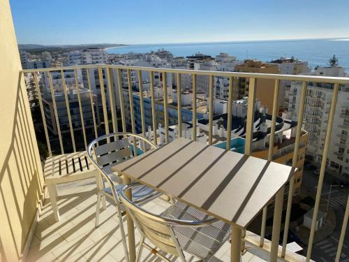 a table and chairs on a balcony with a view of the ocean at Armação de Pêra Vista Mar in Armação de Pêra