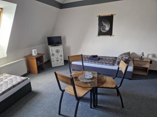 a room with a bed and a table and chairs at penzion U losa in Spořice