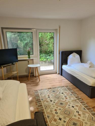 a bedroom with a bed and a couch and a table at WellandHome Aalen - Business Apartment - 4 single beds in Aalen