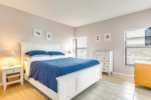 a bedroom with a white bed and two windows at Beachfront New Smyrna Condo: 1 Mi to Flagler Ave in New Smyrna Beach