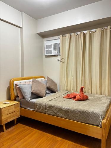 Un dormitorio con una cama con un animal rojo. en Modern 2br Unit in Davao, en Davao City